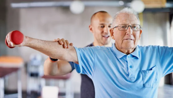 Shot of a physiotherapist helping a senior man with weights