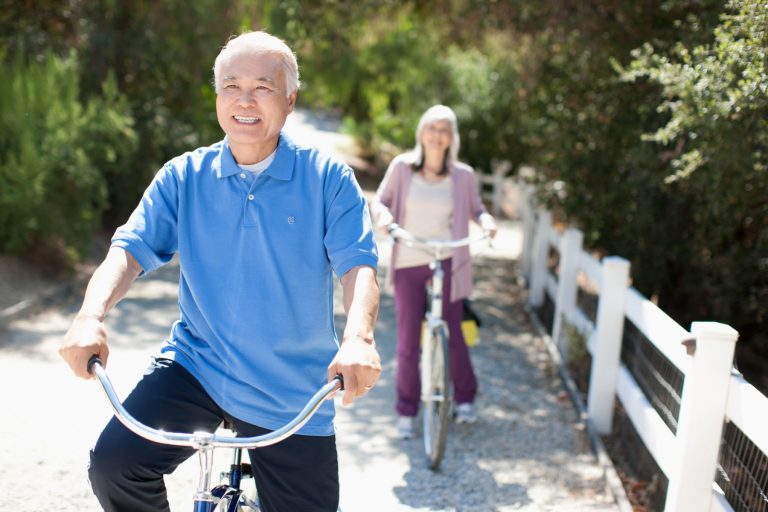 Smiling older couple riding bicycles