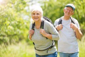 Smiling older woman on a hike with her spouse