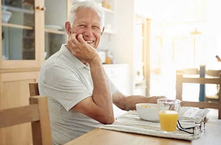 Happy older man having a healthy breakfast