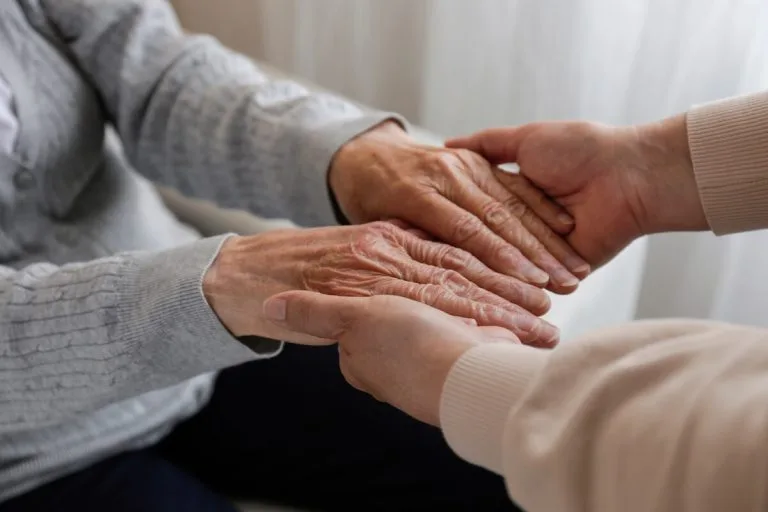 Therapist holding an older woman's hands